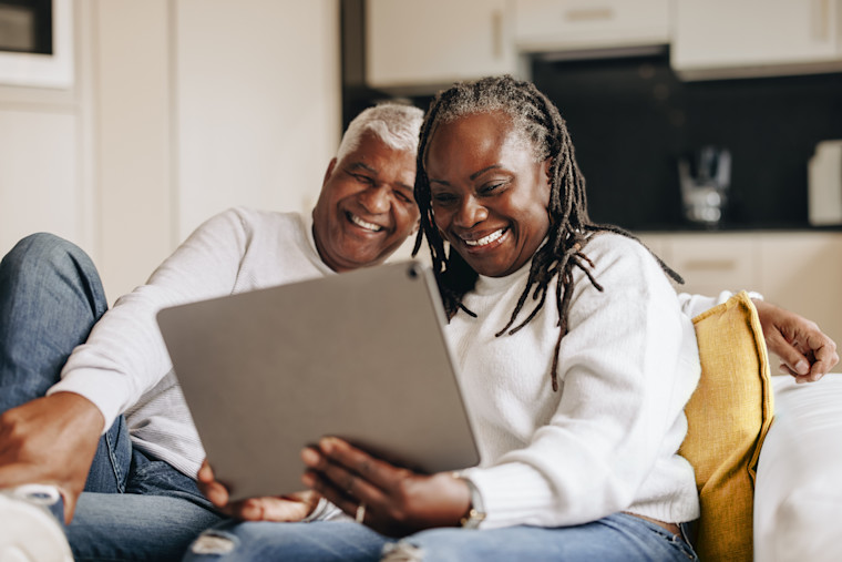 Happy senior couple cataract patients scheduling online with tablet device